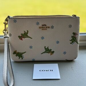 Coach dinosaur wristlet.